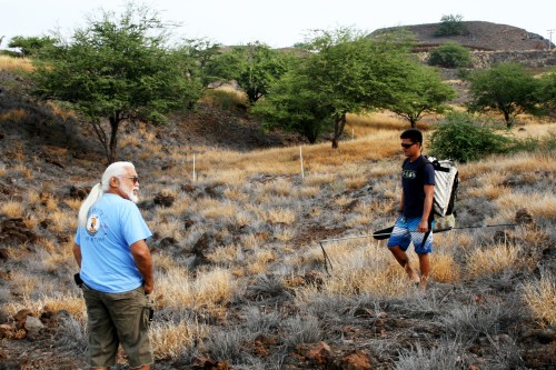 During a tour of the new public access walking trail, Kailapa homesteader Maha Kanealiʻi (in blue) stops to talk to a local fisherman using the Ala Loa Trail to holoholo.
